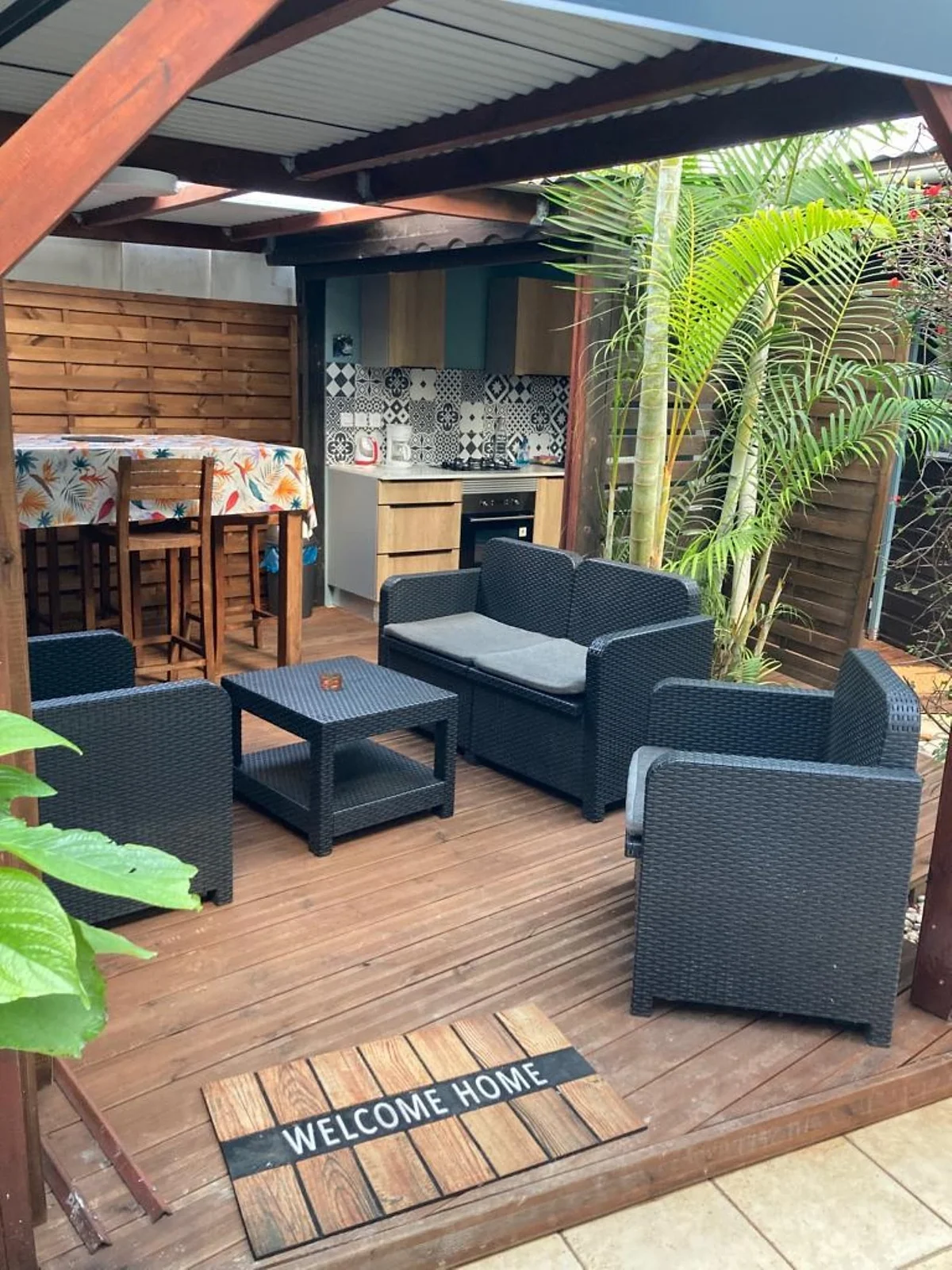 La terrasse couverte du chalet, son salon de jardin et sa cuisine