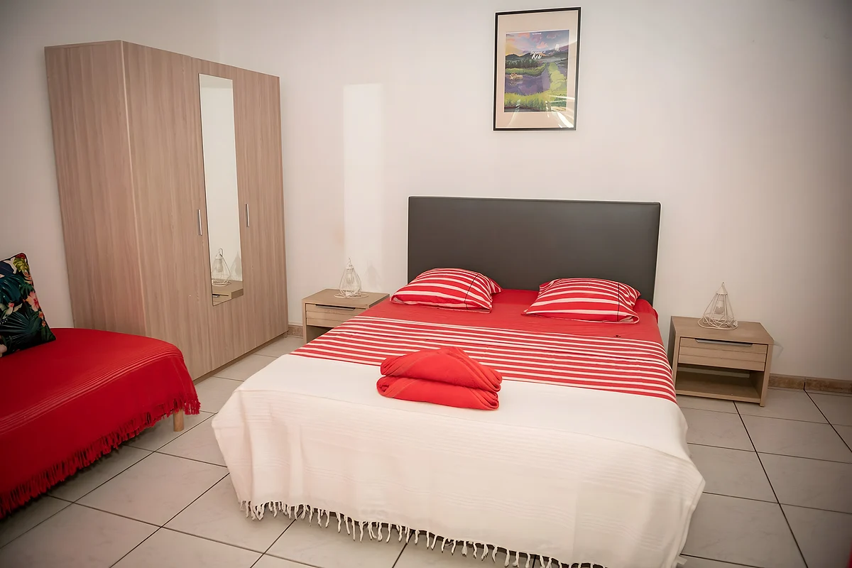 La chambre Hibiscus, lit double au linge rayé rouge et blanc