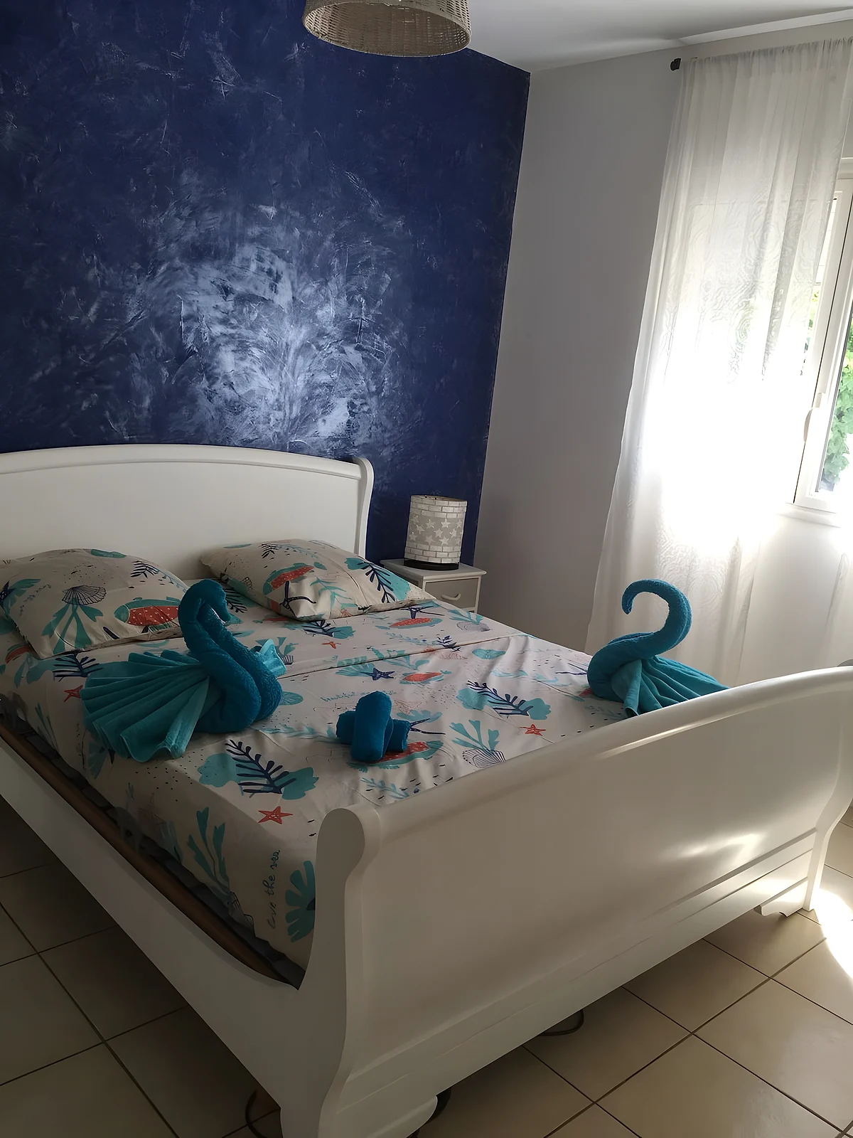 Une chambre du domaine, des cygnes en serviettes posés sur le lit