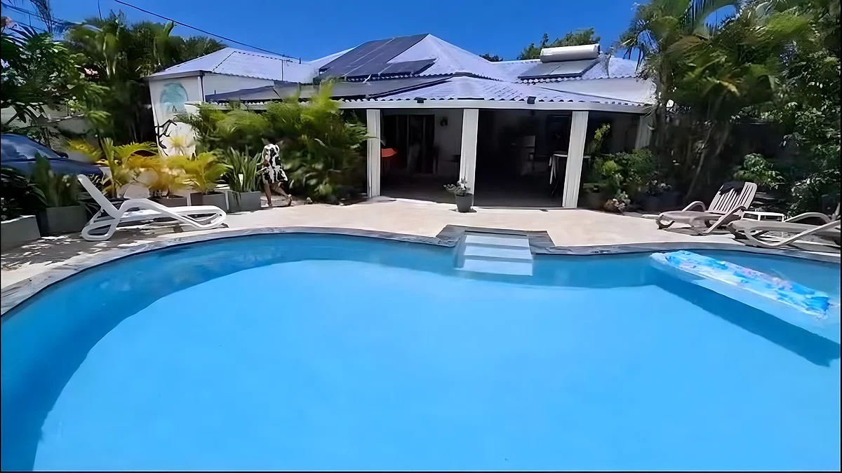La piscine du domaine au soleil, devant la maison et sa varangue