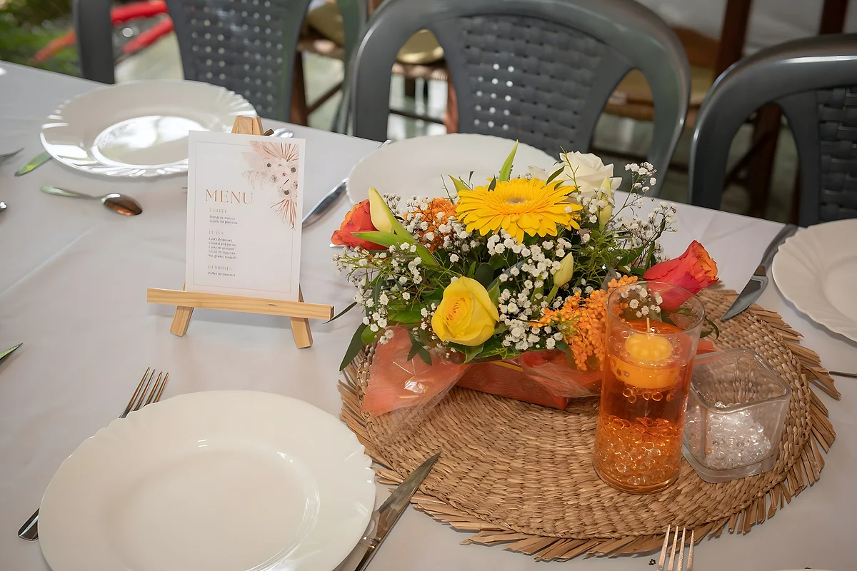 La table dressée pour le dîner, avec son bouquet de fleurs et ses sets en osier