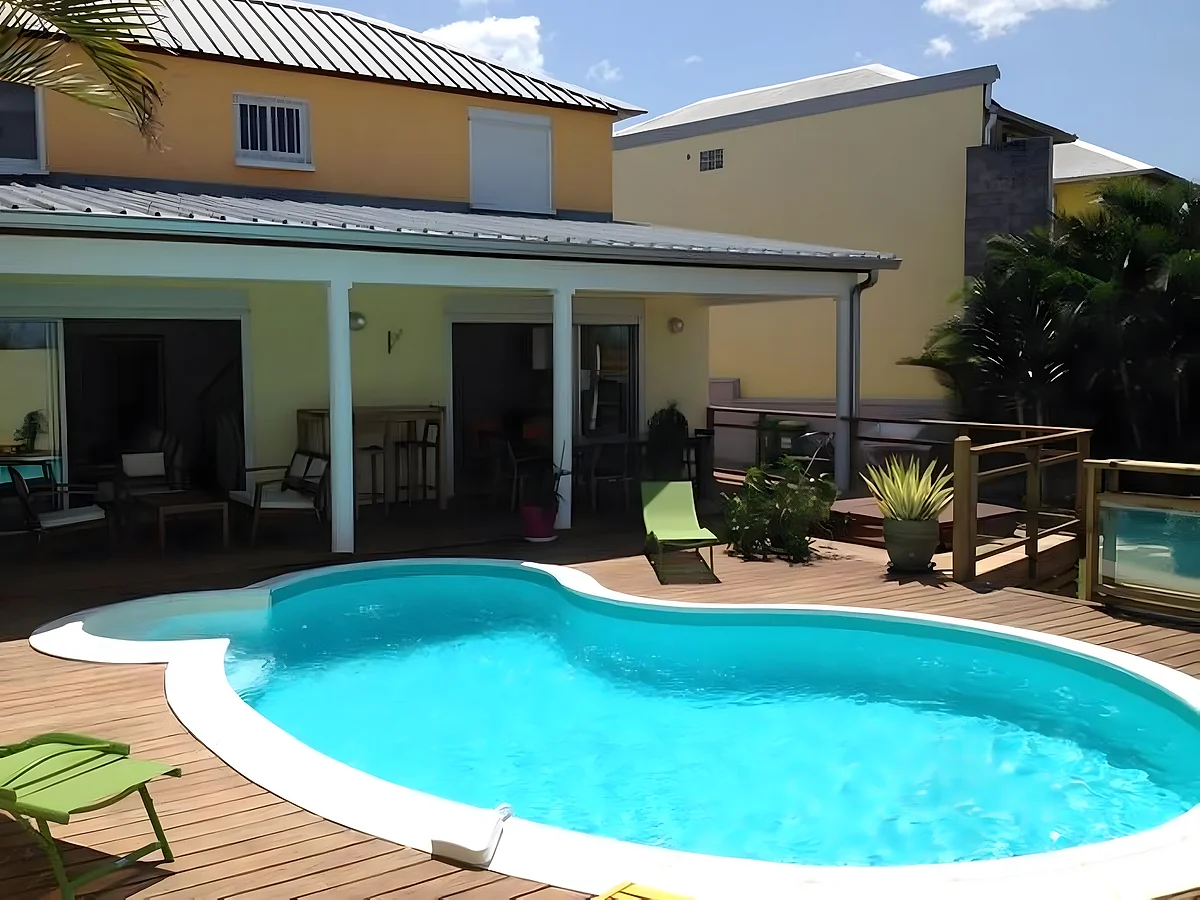 La villa La case à Nath, sa piscine en forme de haricot et sa terrasse en bois
