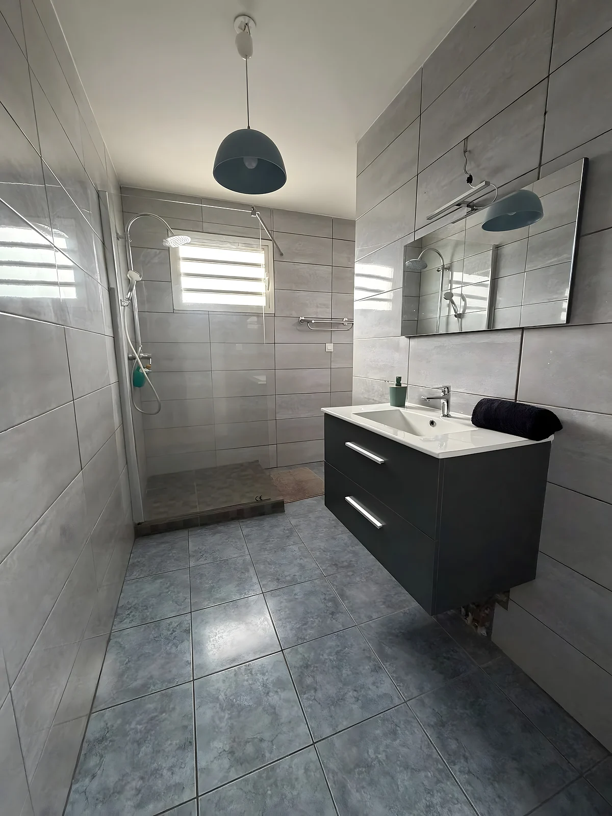 La salle de bain de la villa, douche à l'italienne et meuble gris