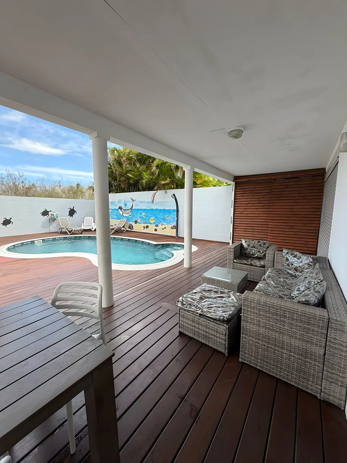 La terrasse couverte et la piscine au fond